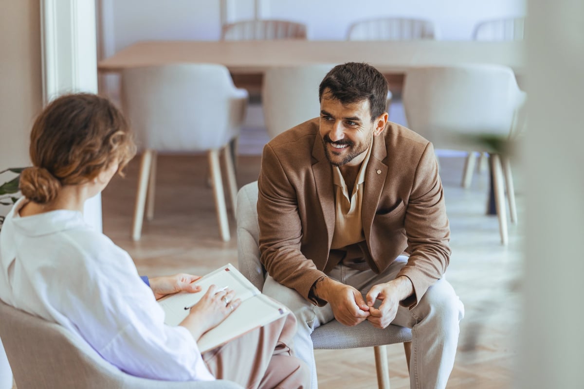 Conversación entre dos personas en un espacio luminoso y moderno, transmitiendo colaboración y confianza